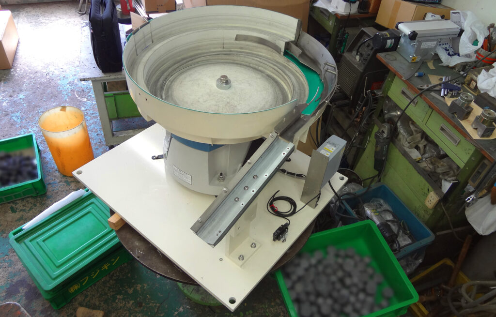 重量のある金属部品を整列・排出するパーツフィーダーです
